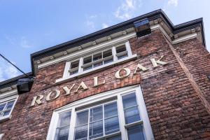 威尔斯浦The Royal Oak Hotel, Welshpool, Mid Wales的一座砖砌建筑,上面有皇家橡木标志