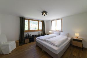 维尔德豪斯Chalet Bergblick的卧室设有一张白色大床和两个窗户。