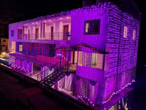 西姆拉Jamunas B&B的建筑的侧面有紫色的灯