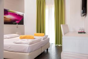 德罗玛索阿格里图尔圣露西亚酒店的一间卧室设有两张床和绿色窗帘