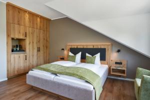 道恩Sporthotel Grafenwald的一间卧室设有一张大床和木墙
