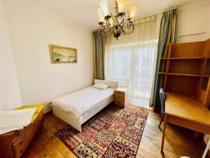乌兰巴托Five seasons guest house的一间卧室配有一张床、一张书桌和一个窗户。