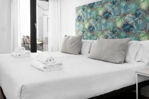 格拉纳达Apartamentos de Isabella的一间卧室配有一张白色床和热带壁纸