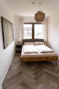 TrierweilerTRIMOSA Apartments - cozy, modern und citynah的一间卧室设有一张床和一个窗口