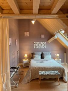 伯夫龙河畔讷安Le Gite De L'etoile Du Jour的一间卧室设有一张大床和木制天花板。