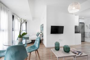 格拉纳达Apartamentos de Isabella的客厅配有玻璃桌和蓝色椅子