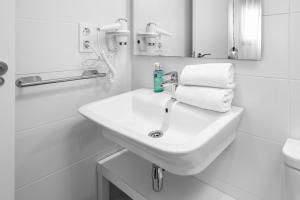 格拉纳达Apartamentos de Isabella的白色的浴室设有水槽和毛巾。