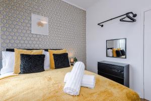 曼彻斯特Beautiful 2 Bedroom House in Manchester Sleeps 7 with Wi-Fi的一间卧室配有一张带黄色毯子的大床