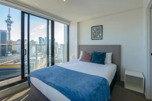 奥克兰Apartment with Brilliant views in Auckland CBD的一间卧室设有一张床和一个大窗户