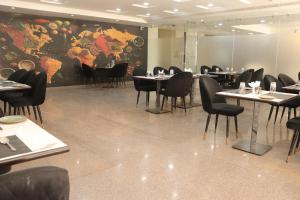 瓜廖尔Hotel maxsun gwalior的一间带桌椅和大型壁画的餐厅