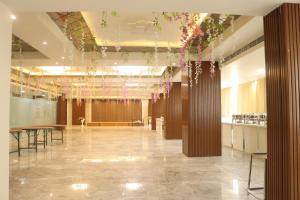 瓜廖尔Hotel maxsun gwalior的大堂设有桌子和天花板上的鲜花