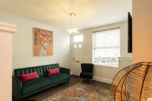 HugglescoteSparkenhoe House的客厅设有绿色沙发和窗户。