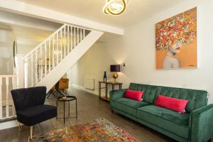 HugglescoteSparkenhoe House的客厅设有绿色沙发和楼梯。