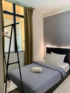 哥打巴鲁Andiana Hotel & Lodge - Kota Bharu City Centre的卧室配有床,靠窗是梯子