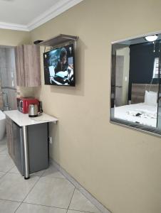 威特班克Sunrise Boutique Hotel的一间设有镜子的墙上电视的房间