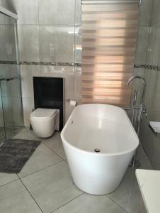 威特班克Sunrise Boutique Hotel的浴室配有白色浴缸和卫生间。