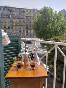 那不勒斯casa vacanze a casa di ciro的阳台上的桌子和两杯葡萄酒