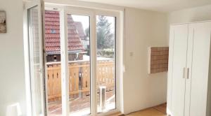 莱奇根home2stay Worker House Feldstetten Kitchen,Wifi,Smart TV Parking ***的客房设有大型滑动玻璃门和阳台