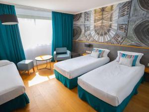 圣米歇尔山圣米歇尔山美居酒店的酒店客房设有两张床和一张桌子。