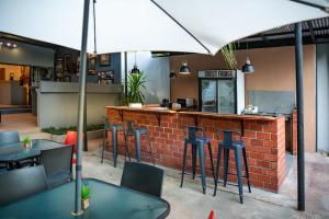 利文斯顿Victoria Falls Backpackers Zambia的酒吧配有桌椅和雨伞