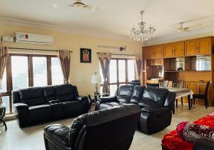 海得拉巴Best Individual Home stay Near Apollo Jubilee Hills的一间带黑色皮革家具的客厅和厨房