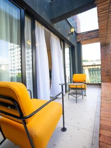 内罗毕Zarafa Suites的一间设有黄色椅子和一张桌子及窗户的房间