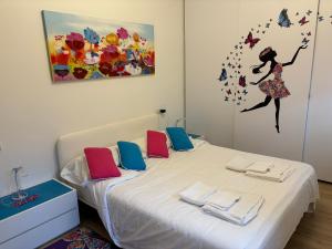 斯特雷萨Un sogno sul lago Home Relax的一间卧室配有带毛巾和绘画的床