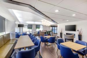 达拉斯Comfort Inn Dallas North Love Field Airport的一间配备有蓝色椅子和桌子的用餐室