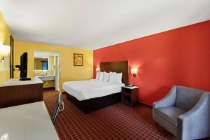 格尔夫波特SureStay by Best Western Gulfport的配有一张床和一把椅子的酒店客房