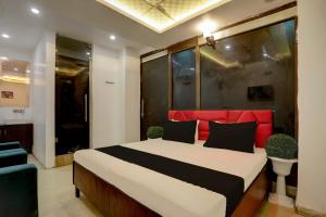 新德里OYO Kashish Residency的一间卧室配有一张大床和红色床头板