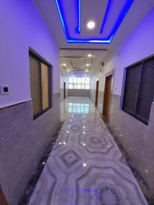 AyodhyaGoroomgo Hotel The Nirmala Palace Ayodhya-Near Ram Mandir的走廊设有蓝色天花板和瓷砖地板