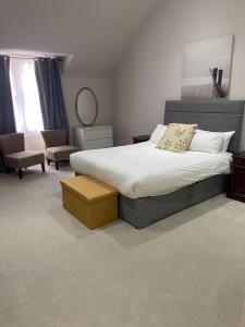 爱丁堡Merchiston Residence的一间卧室配有一张大床和一把椅子