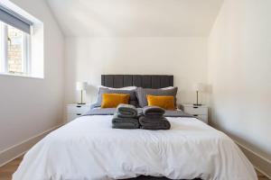 伦敦2BD Mews House, Wanstead的一间卧室配有一张床,上面有两条毛巾