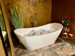 瓦尔季采Residence Barrique Valtice的浴室设有白色浴缸,并装饰有鲜花。