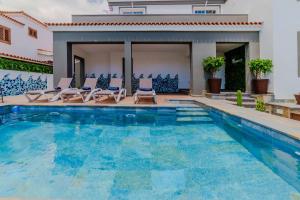 阿罗纳Villa De Marcos的一个带椅子的游泳池以及一座房子