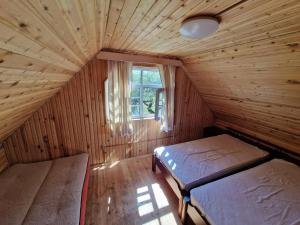 SventeBajāri - Pirts - Banya的小房间设有两张床和窗户