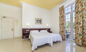 阿尔赫西拉斯全球雷纳克里斯蒂娜酒店的卧室设有白色的床和大窗户