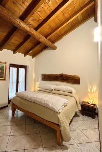 Grandola ed Uniti维奇亚克奥德利亚农家乐的一间带一张床的卧室,位于带木制天花板的房间内