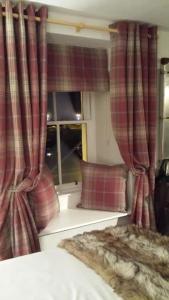 托伯莫里托伯莫里酒店的一间卧室配有红色窗帘、一张床和窗户