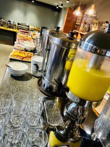 科布列季Hotel Homey Kobuleti的柜台上的搅拌机,配上橙汁杯