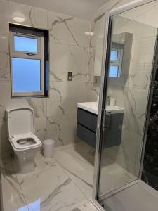 沃特福德Potters Hideout- Warner Bros Studios and London的白色的浴室设有卫生间和窗户。