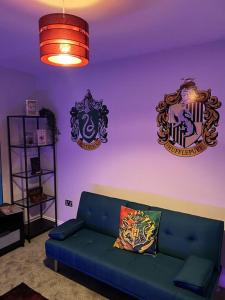 沃特福德Potters Hideout- Warner Bros Studios and London的客厅配有蓝色沙发和2种装饰