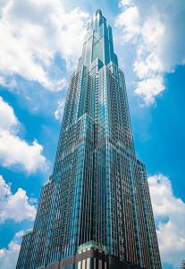胡志明市Merry Land LANDMARK 81的一座高大的玻璃建筑,拥有蓝色的天空和云朵