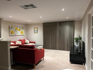 珀斯Applecross 2 Bedrooms by Swan River的客厅设有红色的沙发和窗户。