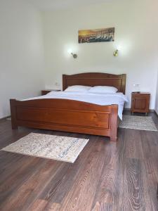 CăciulataCasa Teodora Caciulata的一间卧室设有一张木床,铺有木地板。