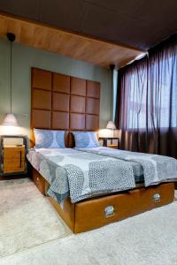 大特尔诺沃Studio77的一间卧室配有一张大床和木制床头板