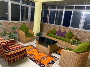 甘托克OYO Home Urvi Griham的带沙发和椅子的客厅以及地毯。