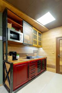 大特尔诺沃Studio77的一间带红色橱柜和微波炉的厨房