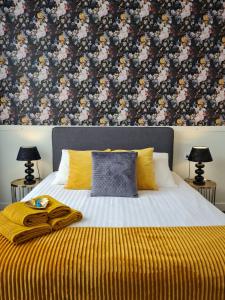 斯海弗宁恩维特胡斯席凡宁根酒店的一间卧室配有一张带花卉壁纸的床