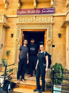 斋沙默尔Explore Hostel Life Jaisalmer的站在一座建筑的台阶上的三个男人